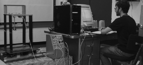 [Student Zach Feinstein uses teleparticipation tools to run an experiment using a shake table to test a single-story structure.]