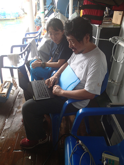 HyeJeong Kim and Hajime Shiobara observing how the first data checks are performed right after the recovery of an ocean bottom seismometer during the Oldest-1 cruise. | 