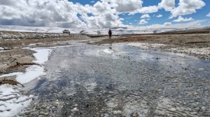 Scientist looks over icy river on Qinghai-Tibet Plateau