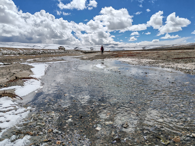 Scientist looks over icy river on Qinghai-Tibet Plateau
